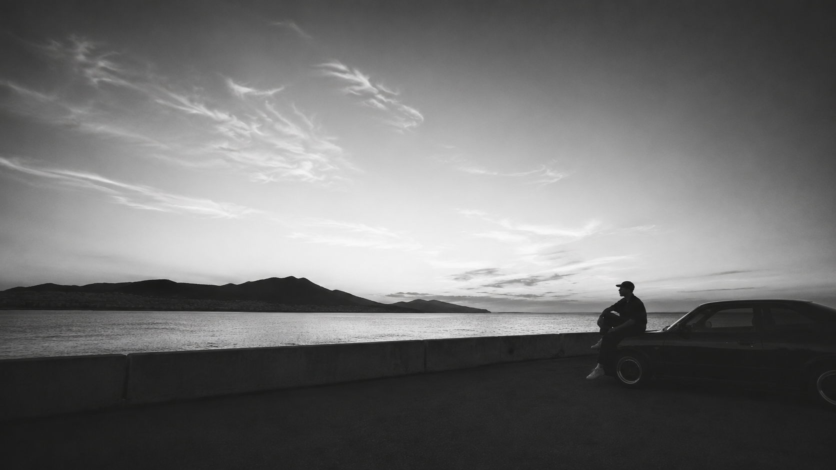 ABERCI, Afro House DJ and producer from Barcelona, cinematic black and white seaside portrait